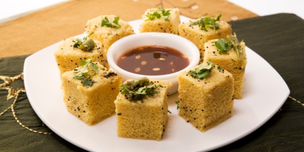 Close-up of freshly steamed Dhokla garnished with coriander and chilies 